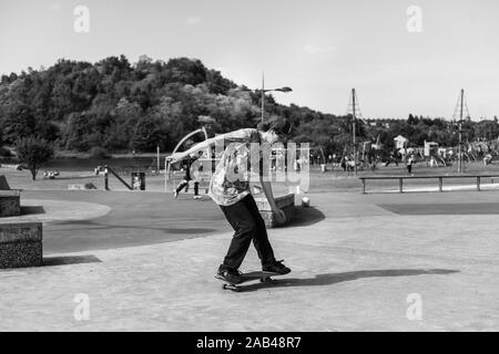 Skateboarders facendo trucchi, praticando ollieing presso i locali di città skatepark in Stoke on Trent, Stoke Plaza Foto Stock