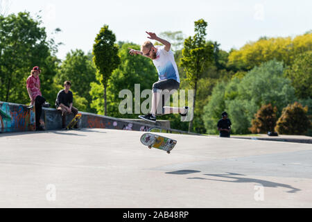 Skateboarders facendo trucchi, praticando ollieing presso i locali di città skatepark in Stoke on Trent, Stoke Plaza Foto Stock