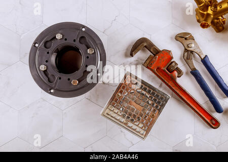 Impianti idraulici e Monkey Wrench sporco bagno in acciaio inox lo scarico della doccia era in stile moderno Foto Stock