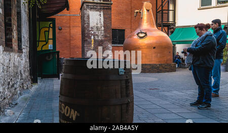 Dublino, Irlanda - 16 Febbraio 2019: turisti tenendo la loro immagine di fronte alla vecchia marca Jameson Irish Whiskey distilleria su una giornata invernale e Foto Stock