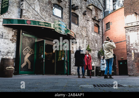 Dublino, Irlanda - 16 Febbraio 2019: turisti tenendo la loro immagine di fronte alla vecchia marca Jameson Irish Whiskey distilleria su una giornata invernale e Foto Stock