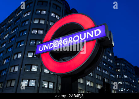 Londra - 20 novembre 2019: Londra metropolitana logo rosso segno stazione ferroviaria di notte Foto Stock