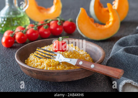 Porzione di risotto alla zucca decorata con pomodoro ciliegino Foto Stock