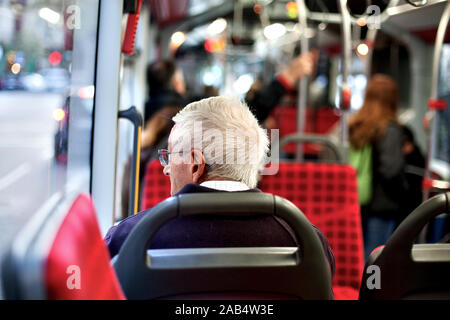 Il vecchio uomo sul bus guardando fuori dalla finestra, Barcelona, Spagna. Foto Stock