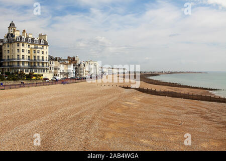 Hotel sul lungomare e pennelli multipli sulla spiaggia di Eastbourne, visto qui su un nuvoloso giorno nel maggio 2019. Foto Stock