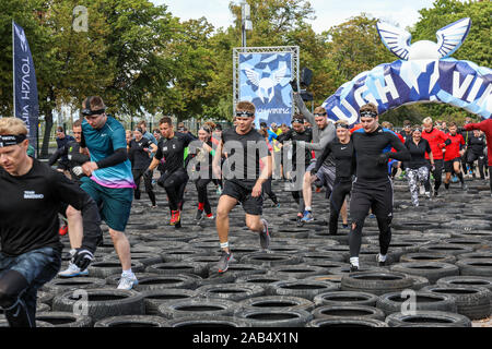 Sebbene Viking partecipanti in esecuzione attraverso il pneumatico ostacolo corso a Helsinki in Finlandia Foto Stock