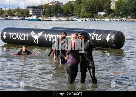 Coppia sorridente dopo immersione in mare a dura Viking ostacolo corso gara a Helsinki in Finlandia Foto Stock