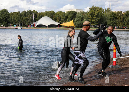 Sebbene Viking ostacolo corso gara i partecipanti ad alta fiving dopo immersione in mare a Helsinki in Finlandia Foto Stock