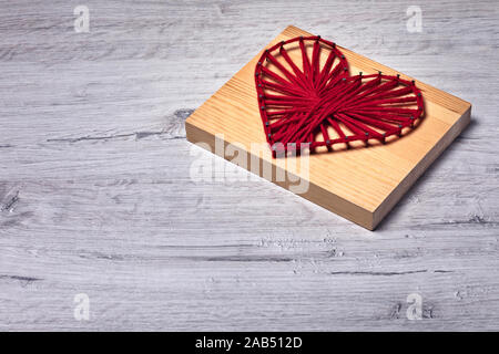 Il giorno di San Valentino è storto arte string cuore rosso con spazio per i messaggi di saluto da foto presa dal basso. Questo file viene pulito e ritoccate. Foto Stock