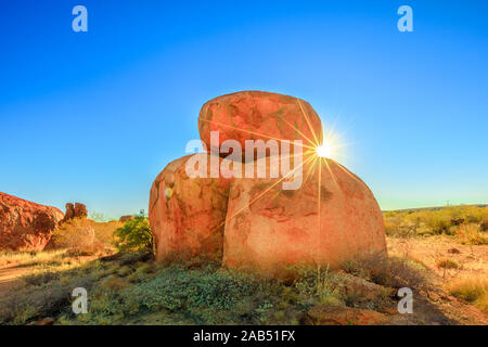 Sunray alla luce del tramonto in Karlu Karlu - Devils Marmi Conservation Reserve. Outback australiano paesaggio nel territorio del Nord, l'Australia vicino Foto Stock