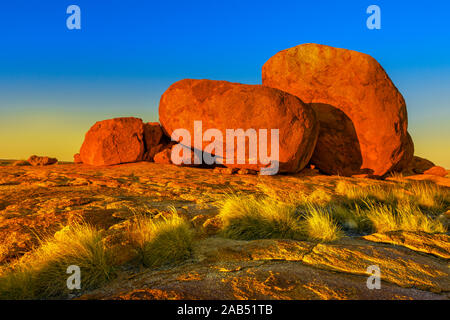 Stupendi paesaggi naturali whit colore rosso intenso al tramonto di diavoli marmi o Karlu Karlu. Massi ciclopici simbolo dell'Australia outback nel Nord Foto Stock