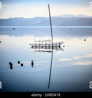 Una barca a vela sul lago di Ohrid a Peshtani nel nord della Macedonia, con l'Albania in distanza, Nord Macedonia, l'Europa. Foto Stock