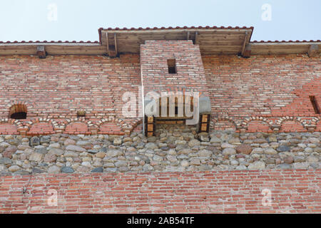 Muro di mattoni di un vecchio castello con wc camere in facciata Foto Stock