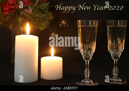 Felice Anno Nuovo 2020 con due bicchieri di champagne e fiori in background Foto Stock