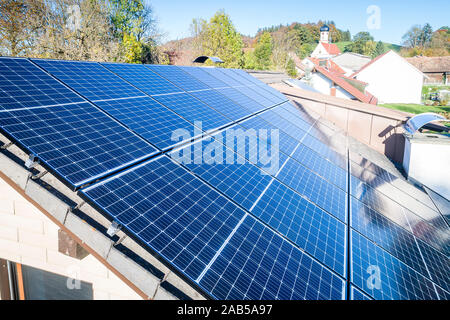 Pannelli solari e solare reflextions sul tetto contro il cielo blu sullo sfondo. Concetto di alimentazione pulita di energia. Foto Stock