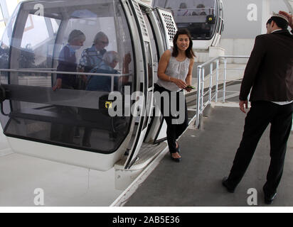 I turisti in uscita di una gondola all'Alem ruota panoramica Ferris ad Ashgabat Foto Stock