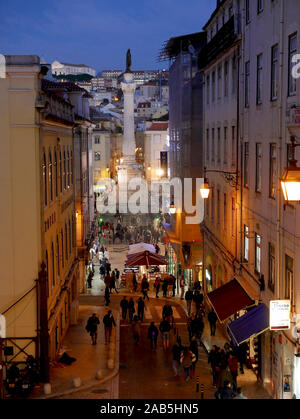 La colonna di Pedro IV nella piazza Rossio (Praca de D. Pedro IV) al crepuscolo in inverno guardando verso il basso dalla Calcada do Carmo Foto Stock