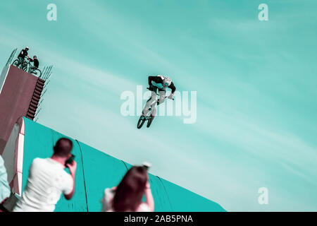 Extreme irriconoscibile ciclista, giovane uomo facendo saltare con la bmx bike sullo sfondo del cielo. Angolo intenzionale all'orizzonte, aumentando i rischi di volo Foto Stock