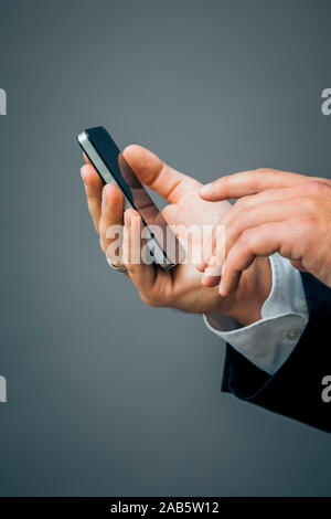 Ein Geschaeftsmann, der ein Mobiltelefon in der haelt a mano Foto Stock