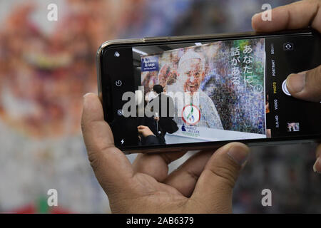 Tokyo, Giappone. 25 Nov, 2019. Una persona che prende una foto di un murale in mostra presso il Tokyo Dome dove Papa Francesco ha dato massa a migliaia di persone in Giappone, la massa è una delle attività del Papa Francesco durante il suo viaggio attraverso alcuni paesi asiatici. Foto scattata il 25 novembre 2019. Foto di: Ramiro Agustin Vargas Tabares Credito: Ramiro Agustin Vargas Tabares/ZUMA filo/Alamy Live News Foto Stock