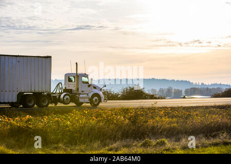 Potente big rig white day cabina di grado industriale semi carrello per il recapito locale il trasporto commerciale cargo in coperta bulk ondulato semi rimorchio dr Foto Stock