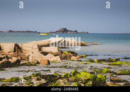 Giallo barca lungo le coste delle isole di Guernsey con rocce e spiaggia - isole del canale Foto Stock