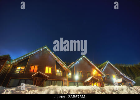 Casa di montagna nella neve durante la notte Foto Stock