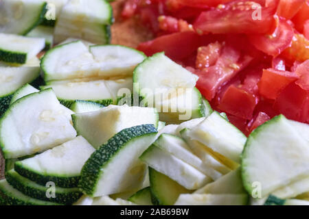 Tagliere con taglio fresco verde biologico zucchine e pomodori rossi Foto Stock