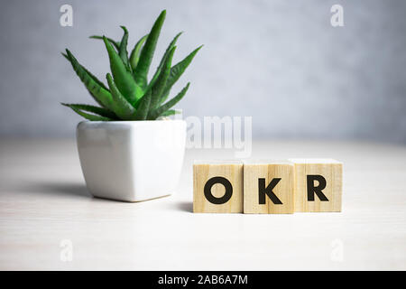 OKR parola scritta sul blocco di legno. abbreviazione di obiettivo i risultati chiave testo sul tavolo in legno per il desing, concetto. Foto Stock