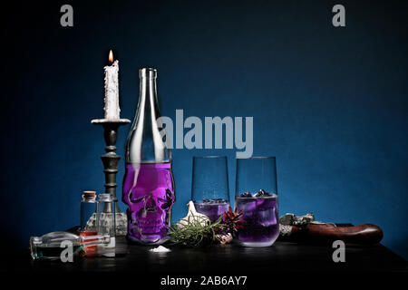 Cranio a forma di bottiglia contenente una bevanda di colore viola Foto Stock