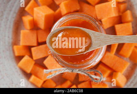 Dolci fatti in casa marmellata di zucca in cucchiaio sopra la zucca a pezzi nel plate.Organic sano cibo vegetariano. Messa a fuoco selettiva,orizzontale. Foto Stock