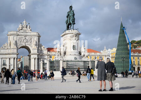 Lisbona, Portogallo. 25 Nov, 2019. I turisti e i venditori ambulanti di passeggiata nella piazza del commercio di fronte all'arco trionfale della strada Augusta (l) e la statua equestre di Josés I. Credito: Lisa Ducret/dpa/Alamy Live News Foto Stock