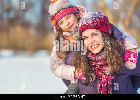 Active madre e figlia giocando in winter park Foto Stock
