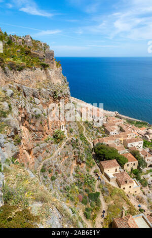 Vista dalla parte superiore di Monemvasia giù per la collina, che mostra la città antica di seguito il percorso di pietra per la parte superiore e il Mare Egeo. Foto Stock