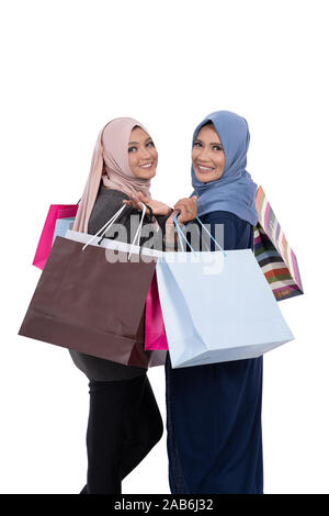 Due donne velate che trasportano shopping bag Foto Stock