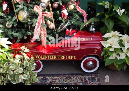 Un bambino di dimensioni del camion dei pompieri sotto un albero di natale, presso il volontario Park Conservatory a Seattle, Washington, Stati Uniti d'America. Foto Stock