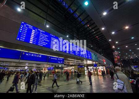 VIENNA, Austria - 30 ottobre 2019: scheda di partenze di Wien Hauptbahnhof con passeggeri in fretta e in attesa di prendere i treni nella stazione ferroviaria principale Foto Stock