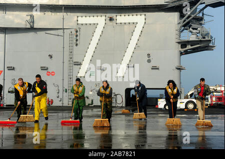 Oceano atlantico (dec. n. 2, 2012) i marinai a bordo della portaerei USS George H.W. Bussola (CVN 77) scrub il ponte di volo. George H.W. Bush sta conducendo esperimenti in mare in collaborazione con Norfolk Naval Shipyard per la formazione di marinai e di assicurare il funzionamento di apparecchiature e sistemi a seguito del completamento di una di quattro mesi incrementale previsto periodo di disponibilità. Foto Stock