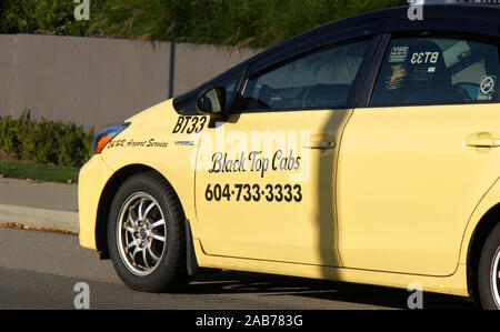 Vancouver, Canada - Ottobre 5,2019: Immagine ravvicinata di un top nero Cabs taxi è attesa per il passeggero intorno nessun segno di arresto nel centro cittadino di Vancouver Foto Stock