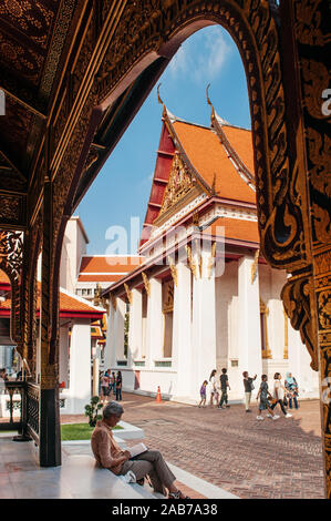 OCT 24, 2019 Bangkok, Thailandia - Museo Nazionale di Bangkok palazzo anteriore trono hall visto attraverso il golden padiglione Thailandese telaio porta con tourist sit godere Foto Stock