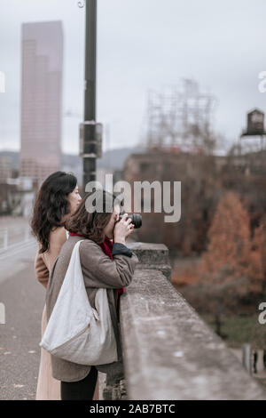 Portland, Oregon - Nov 16, 2019 : due viaggiatori asiatici guardando William fiume sul ponte di Burnside nel centro di Portland Foto Stock