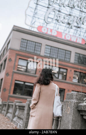 Portland, Oregon - Nov 16, 2019 : femmina asiatica guardando un inconfondibile segno di Portland in Portland Foto Stock