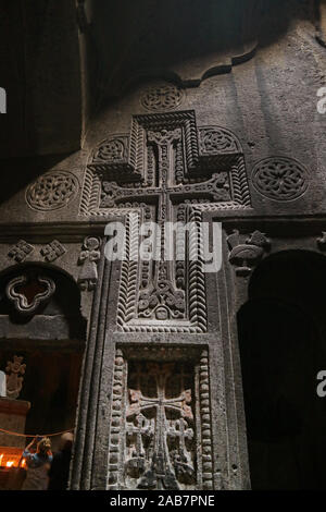 Croce e un altro Carving motivi su muro interno antico Rock-cut chiesa del Monastero di Geghard complessa, Armenia Foto Stock