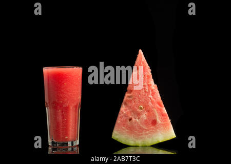 Frullato di anguria con fette di anguria isolati su sfondo nero. Foto Stock