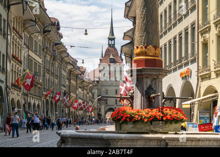 I turisti lungo Marktgasse, strada dello shopping nel centro storico (Altstadt) con torre Kafigturm in background, Berna, Svizzera, Europa Foto Stock