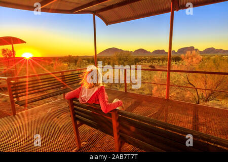 Tourist donna seduta su una panchina in corrispondenza della piattaforma dune area di visualizzazione di Mount Olga nell'Uluru-Kata Tjuta National Park, UNESCO, Australia Foto Stock