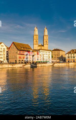 Tramonto sulla cattedrale Grossmunster e Limmatquai street lungo le rive del fiume Limmat, Zurigo, Svizzera, Europa Foto Stock