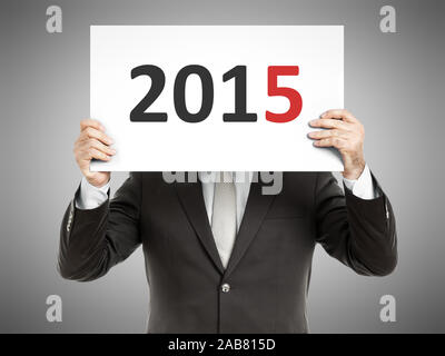 Ein Geschaeftsmann, der ein Schild mit der Zahl '2015' haelt Foto Stock