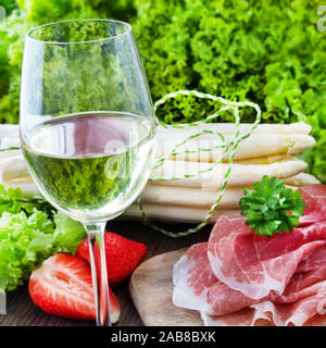 Vino bianco e asparagi con prosciutto Foto Stock