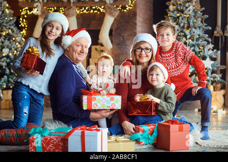 Nonna e nonno con i bambini a casa durante il periodo di Natale. Foto Stock